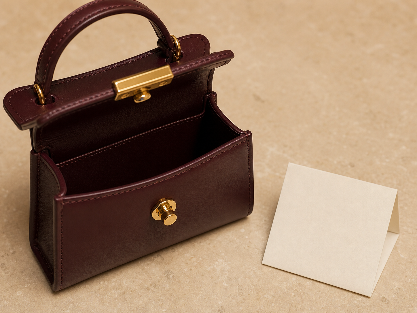 Open mini top-handle bag showing a card case and lipstick inside