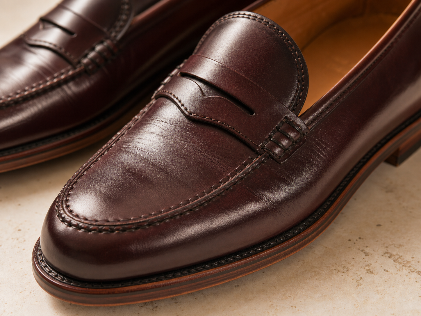 Close detail of burgundy loafer stitching and leather grain